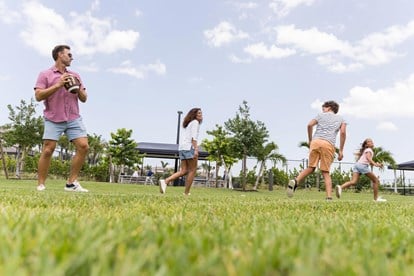 Family playing football outside Clubhouse